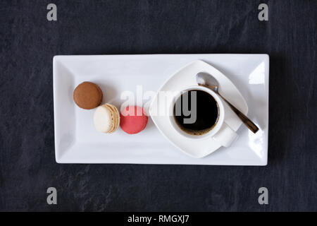 Tazza di caffè e tre macaron. Foto Stock