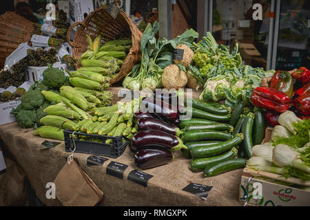 Verde di generi alimentari comprese le zucchine, melanzane, asparagi, peperoni rossi e i broccoli in vendita su una verdura in stallo un allevatore locale mercato. Foto Stock