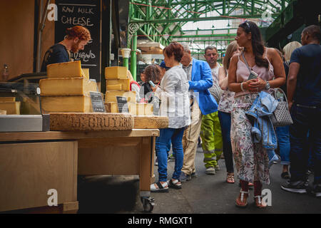 London, Regno Unito - Giugno, 2018. Svizzero di formaggio gruviera in vendita in una fase di stallo nel mercato di Borough, uno dei più antichi e più grande mercato alimentare a Londra. Foto Stock