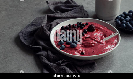 Smoothy di fresco bog mirtilli e lamponi nella ciotola vicino igienico Foto Stock