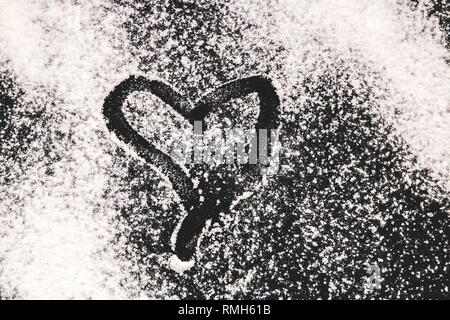 Sfondo di cottura con forma di cuore e la farina a fontana sul tavolo scuro. Copia spazio per il testo. Foto Stock