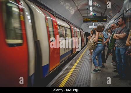 London, Regno Unito - Febbraio, 2019. Le persone in attesa di un treno su una piattaforma della metropolitana. Il tubo gestisce fino a 5 milioni di passeggeri al giorno. Foto Stock