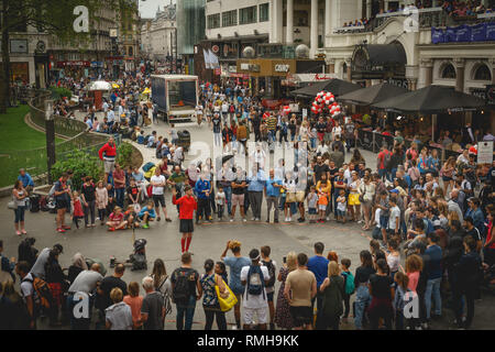 London, Regno Unito - Febbraio, 2019. Un artista di strada esibirsi di fronte ad una grande folla in Leicester Square. Foto Stock