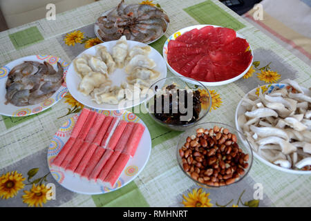 Il cibo fresco preparato per il cinese hot pot. Cibo per ebollizione in zuppa: fette di carne di manzo, gnocchi con carne di maiale e le verdure, i gamberetti, surimi. Anche Mun mus Foto Stock