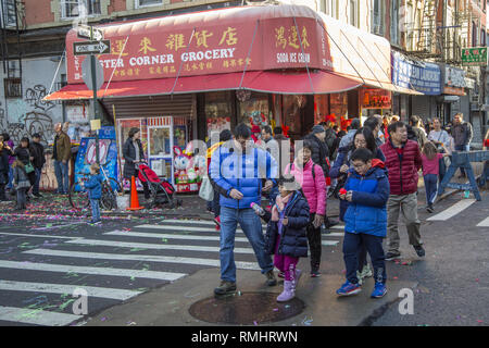 Le famiglie e i bambini in giro per il nuovo anno lunare nella Chinatown di New York City dove la città ha dichiarato che un periodo di vacanze scolastiche per i bambini. Foto Stock