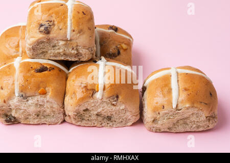 Sei hot cross panini, britannica tradizionale cibo Pasqua su sfondo rosa, il fuoco selettivo Foto Stock