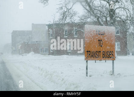 Su Downie Street a Stratford, Ontario, possiamo vedere un segno di traffico che ci chiede di resa per il transito degli autobus che esce dal terminale. Tempesta squall in inverno. Foto Stock