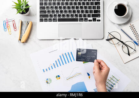 Concetto di una donna che sta facendo un acquisto online, mock up card e cellulare sulla scrivania in ufficio isolato in modo bello sfondo marmo, copia di spazio, Foto Stock