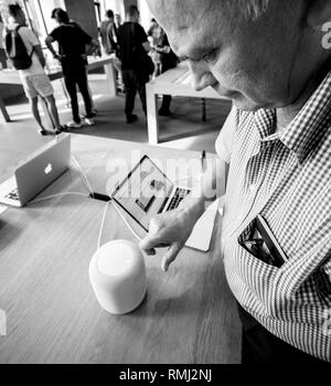 Strasburgo, Francia - Sep 21, 2018: curioso senior uomo HomePod test smart speaker in Apple Store durante l'iPhone Xs e Xs Max preorder per Xr e guardare la serie 4 wearable smartwatch - bianco e nero Foto Stock