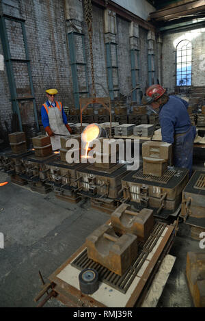Foundrymen pour ferro fuso in stampi per la produzione di griglie di fuoco Foto Stock