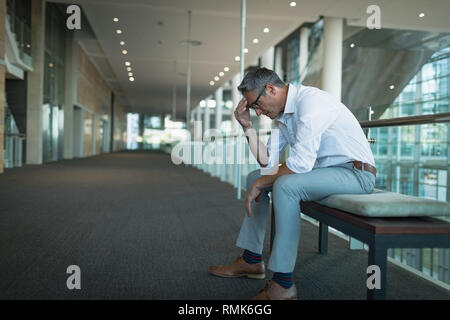 Imprenditore frustrato seduta sul banco di lavoro in ufficio Foto Stock