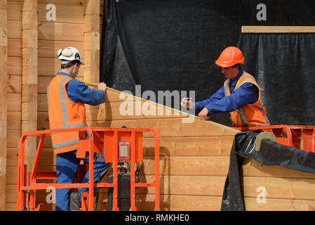 Costruttori misurare la parete di un lockwood edificio di stile Foto Stock