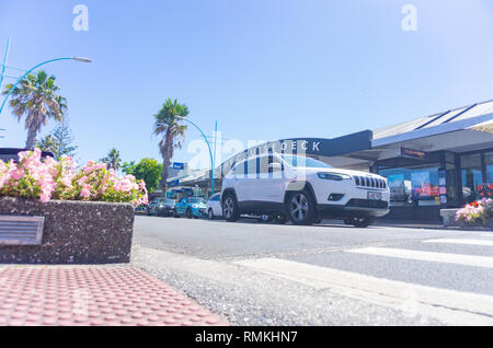 MOUNT MAUNGANUI NUOVA ZELANDA - 8 febbraio 2019: Maunganui Road nella principale area dello shopping con passaggio di veicoli e persone e in bianco e nero CruiseDeck sh Foto Stock