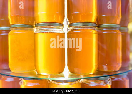I vasetti con fatti in casa miele biologico.Vari barattoli di miele sono venduti in stallo. Foto Stock
