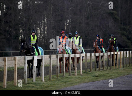 I cavalli e i loro cavalieri l esercizio lungo la collina di Warren galoppa in Newmarket Suffolk. Le corse di cavalli in Gran Bretagna riprenderanno domani a seguito di un 6 giorno Foto Stock
