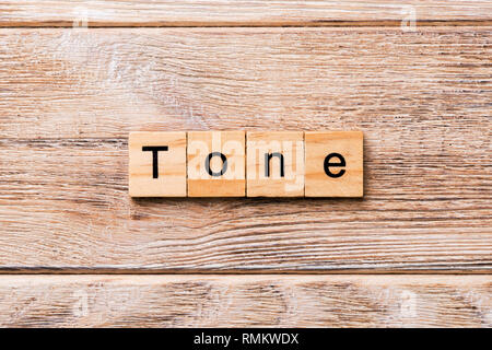 Tono parola scritta sul blocco di legno. tono testo sul tavolo in legno per il desing, concetto. Foto Stock