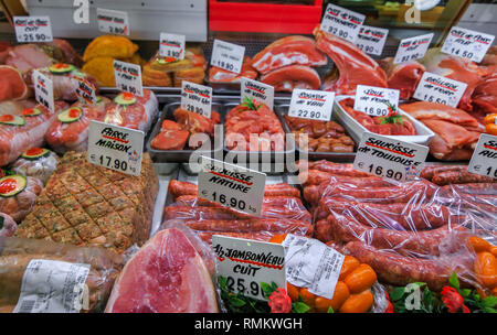 Banco espositore di una tipica macelleria francese con diversi tipi di carne, prosciutto, salsicce, guance di maiale, reni di vitello, ed altri prodotti di carne Foto Stock