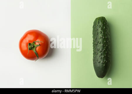 Mature materie organiche cetriolo pomodoro in bicromia bianco colore verde chiaro di combinazione sfondo. Dieta bilanciata vegane superfoods uno stile di vita sano concetto. Foto Stock