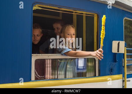 Kiev, Ucraina - 3 Agosto 2013: il conduttore ragazza dà un segnale per la partenza dei carri dei figli di ferrovia a Kiev (Kiev), l'Ucraina. Foto Stock