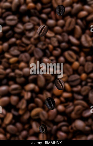 Close-up di chicchi di caffè caduta su un pacco di caffè in grani Foto Stock