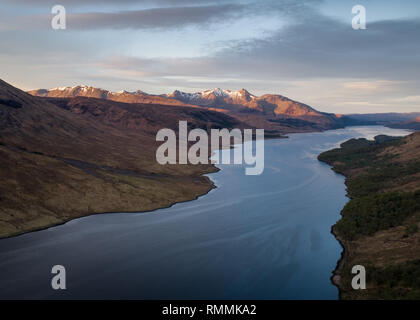 Vista aerea del Loch Etive, alla fine di Glen Etive, come aurora rompe sulle lontane montagne dalle vette innevate, Highlands scozzesi Foto Stock