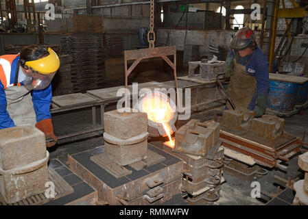 Foundrymen pour ferro fuso in stampi per la produzione di griglie di fuoco Foto Stock