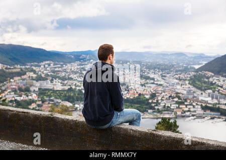 Il giovane uomo in alto punto di vista della città di Bergen in Norvegia. Foto Stock