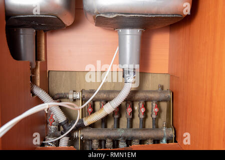 Vecchi lavandini e tubazioni di caldaie che necessitano di riparazione. Foto Stock