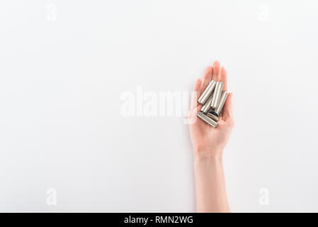 Vista parziale di donna che mantiene le batterie su sfondo grigio Foto Stock