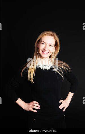 Close up studio ritratto di una bella donna in abito nero su sfondo nero Foto Stock