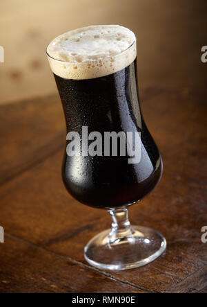 Calice con fresca birra Stout con uno spessore di schiuma in vista ravvicinata Foto Stock