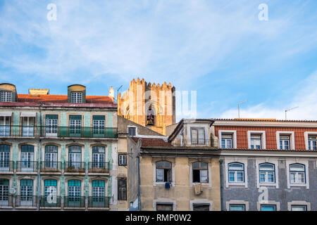 Vista sulla strada del quartiere di Alfama a Lisbona Portogallo con la Cattedrale Sé salendo dietro le righe del tradizionale vicini edifici di appartamenti Foto Stock