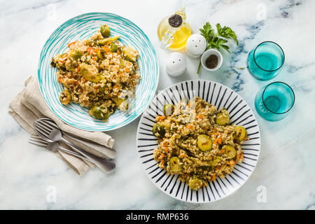 Risotto primavera su di una tavola di marmo con spezie e olio di oliva Foto Stock