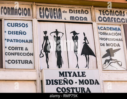 In vecchio stile anni cinquanta style figura femminile moda disegni su shopfront, Malaga, Andalusia, Spagna Foto Stock