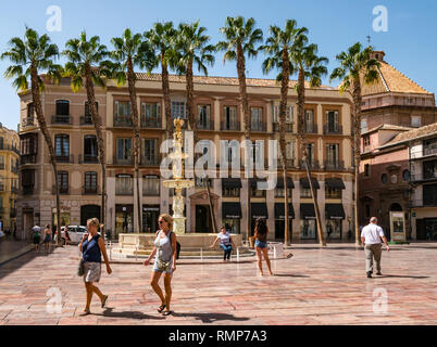 Edifici vecchi e fontana in marmo di Genova, con donne che indossano pantaloncini a piedi nella Plaza de la Constitucion o Piazza della Costituzione, Andalusia, Spagna Foto Stock