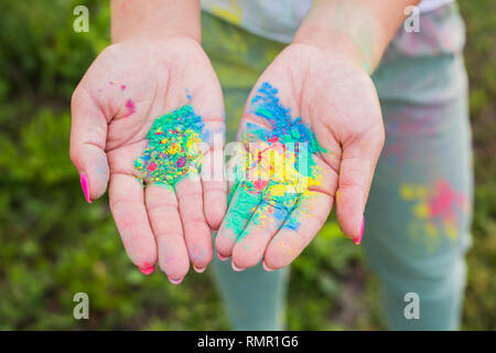 Holi festival e il concetto di colore - mani con giallo, blu, verde Foto Stock