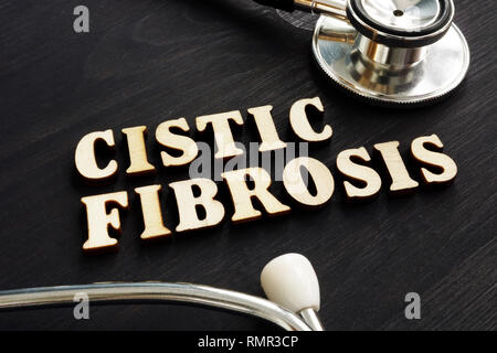 La diagnosi di fibrosi cistica e uno stetoscopio in legno scuro. Foto Stock