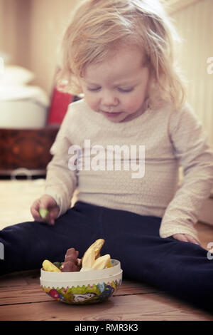 Il Toddler girl avente uno snack Foto Stock