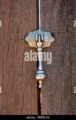 Respingente di metallo su una vecchia porta di legno Foto Stock