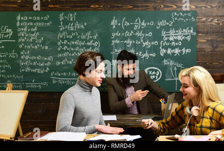 Felice gli studenti universitari che studiano con libri in biblioteca. Lo studente è consapevole del fatto che egli è una parte importante del gruppo. Gli studenti mai procrastinare Foto Stock