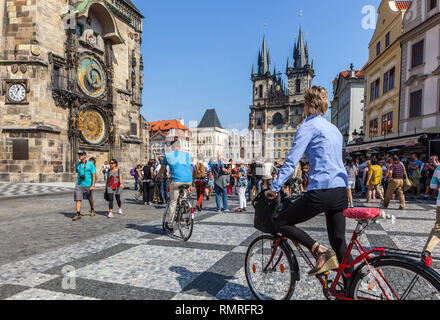 Turisti di Praga in bicicletta Piazza della città Vecchia di Praga Turismo in bicicletta Praga Repubblica Ceca Europa persone in bicicletta Tour della città di Praga in bicicletta Foto Stock