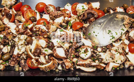 Cucina mediterranea e gustosa insalata di polpo con olive, pomodori ciliegia e prezzemolo Foto Stock