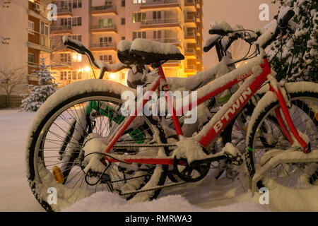 Bucarest, Romania - 7 Gennaio 2019: Biciclette sotto la neve, di notte, dopo una tormenta di neve, parcheggiata vicino ad un edificio residenziale area nel settore 3, Buchar Foto Stock