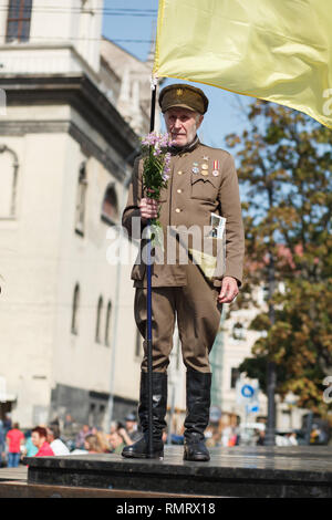 Lviv, Ucraina - 24 agosto 2017: un veterano dell'Ucraina esercito di insorti detiene una bandiera dell'Ucraina. Giorno di indipendenza dell'Ucraina Foto Stock