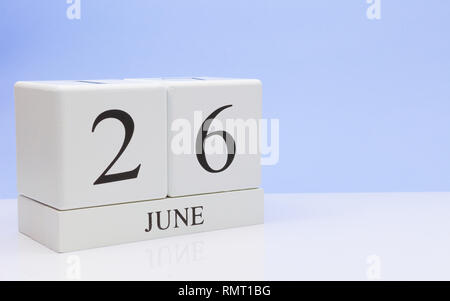 Giugno 26st. Giorno 26 del mese, il calendario giornaliero sul tavolo bianco con la riflessione, con luce sfondo blu. Orario estivo, spazio vuoto per il testo Foto Stock
