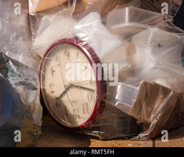 Edimburgo, Scozia - 11 Maggio 2015: uno spreco di tempo. Fotografia che mostra un orologio di office all'interno di sacchetti di plastica della spazzatura accatastati in una strada della citta'. Foto Stock