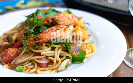 Close up vista laterale spicy spaghetti mescolare il pesce fritto cibo tailandese, tum yum talay Foto Stock