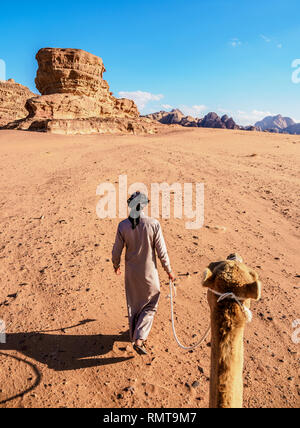 Bedouin camminando con il suo cammello, Wadi Rum, Governatorato di Aqaba, Giordania (MR) Foto Stock