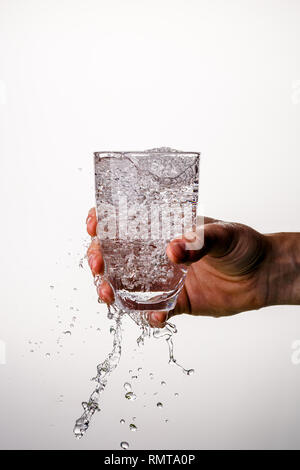 Vetro con versando acqua, bolle Foto Stock