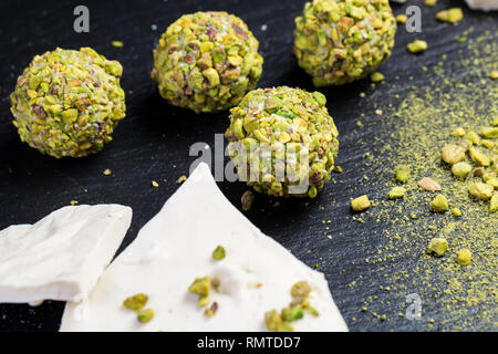 Tema dolce dessert torta fatta a mano. Macro Close-up dessert dessert dolciumi dolce palla rotonda tartufo bianco delle sfere di cioccolato bianco, matcha tè e pis Foto Stock